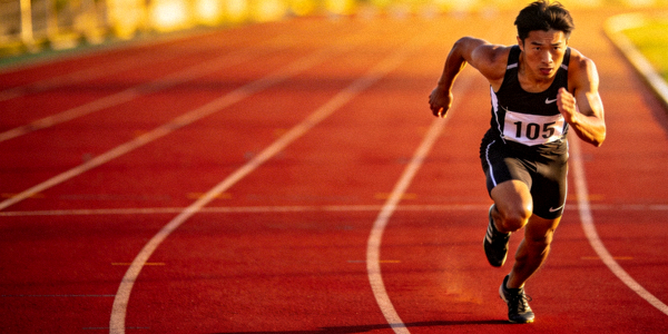 田径运动员在跑道上冲刺的瞬间照片
